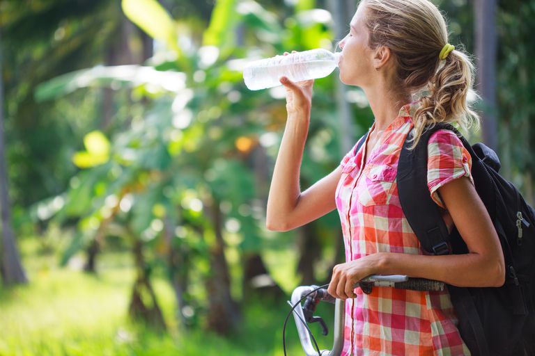 יפה young woman drinking water after bicycling