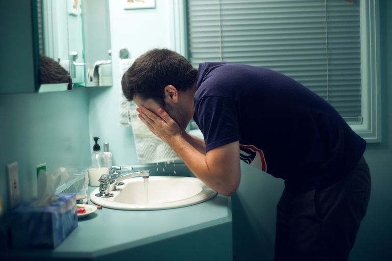 איש washing his face with tap water